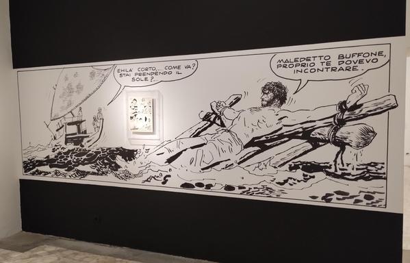 A panel of a black and white comic in full size on a wall.